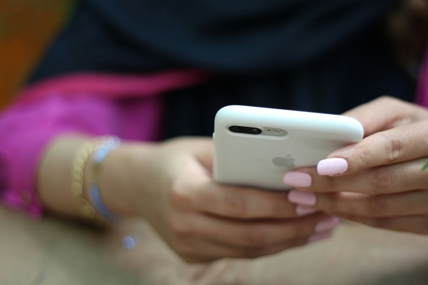 A consumer scrolling on a phone in a busy social environment